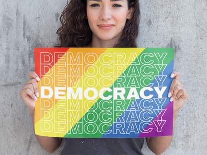 Woman holding up a small Democracy Rainbow Poster. So Right They’re Wrong. So Right They’re Wrong. So Right Their Wrong